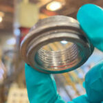 Primer plano de un acoplamiento de calentador de agua limpiado y protegido con ZERUST Axxatec DA-23C, que muestra el revestimiento protector invisible.