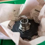 Pieza metálica envuelta en papel Kraft VCI para protección contra la corrosión.