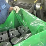 Empleado de manufactura transportando partes estampadas en Película VCI ZERUST