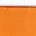 Aceite preventivo contra la corrosión que no mancha vertido sobre una pieza metálica para mostrar su viscosidad.