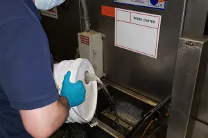 Technician servicing parts cleaner fluid management system