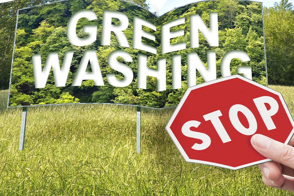 Cartelera con la frase "greenwashing" y una señal de alto al frente.