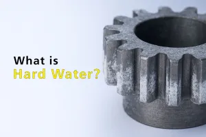 Close-up of a metal gear with hard water deposits, highlighting the need for a hard water parts cleaner